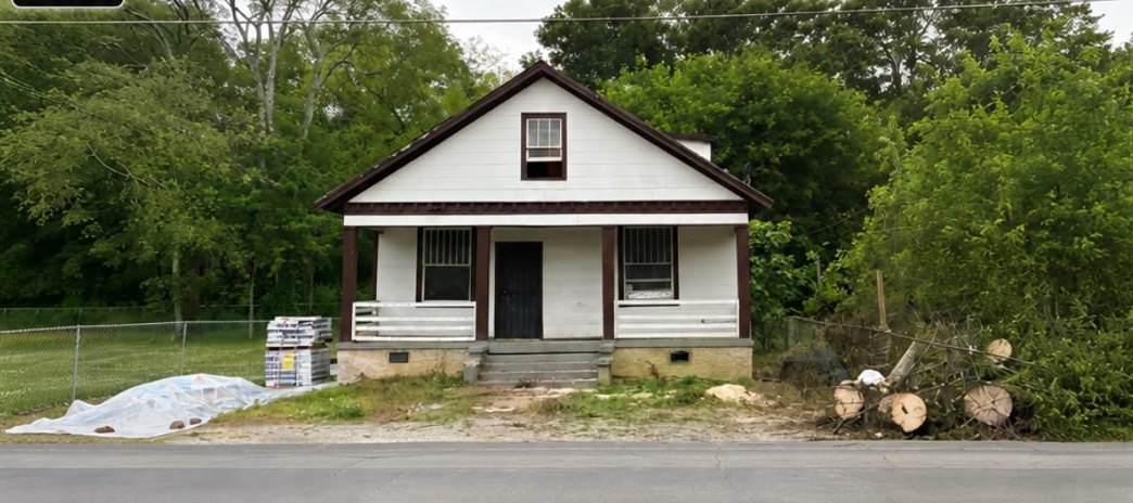 1713 S Orchard Knob Ave before — dated white cottage with worn porch in Chattanooga