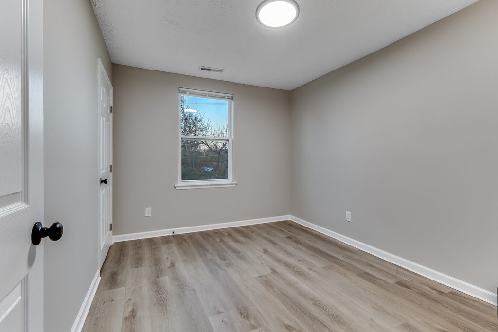 Renovated bedroom in Chattanooga — natural light, new window trim, and LVP flooring