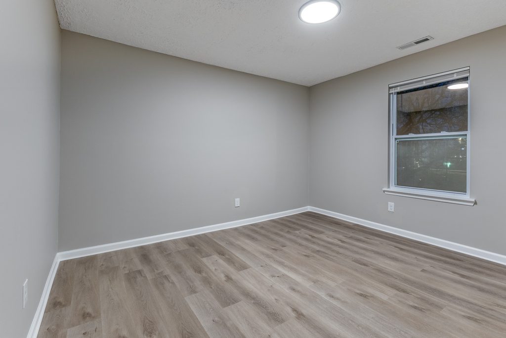 Renovated bedroom in Chattanooga — fresh greige paint, new LVP flooring, and clean trim