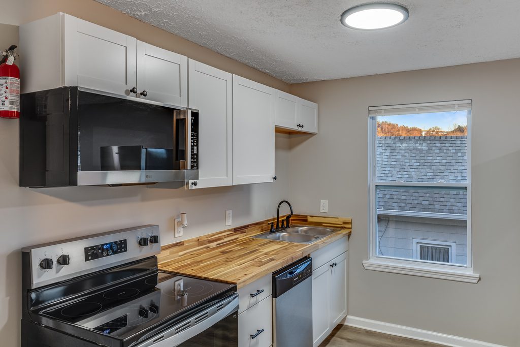 Renovated kitchen in Chattanooga — butcher block countertops, black faucet, and new window trim