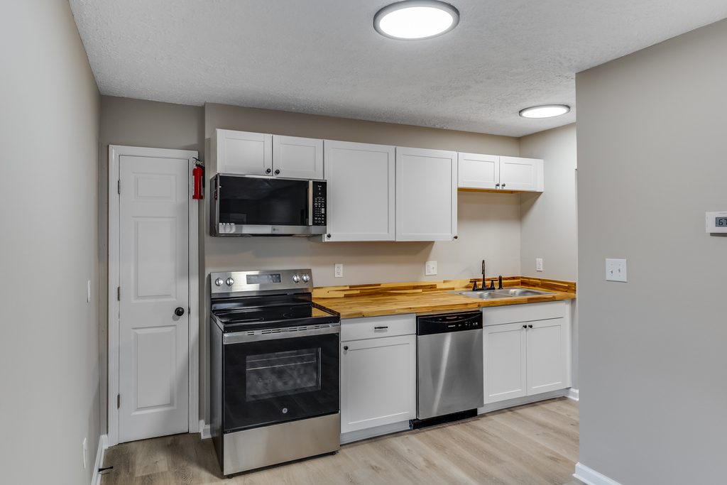 Open-concept kitchen renovation in Chattanooga — white shaker cabinets, butcher block counters, and stainless appliances