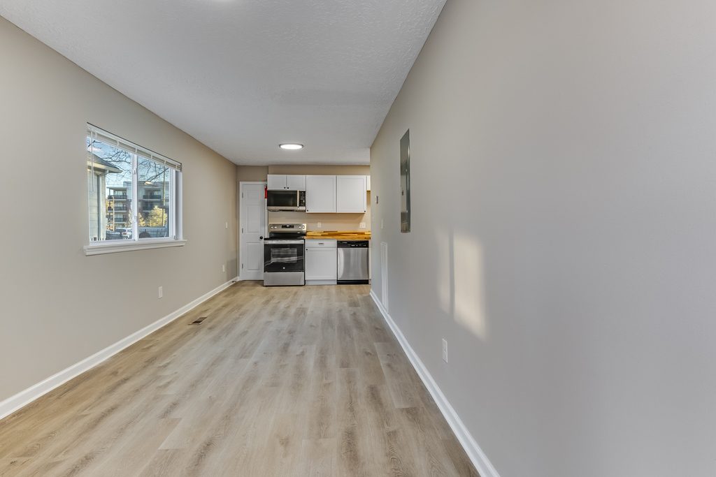 Open living and kitchen layout after a full interior renovation in Chattanooga — new LVP flooring and fresh paint
