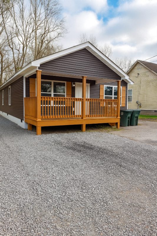 1630 S Greenwood Ave after — fully renovated rental with dark gray siding and cedar porch in Chattanooga