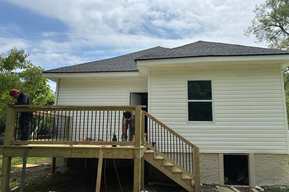 Mid-construction exterior in Chattanooga — new roof, soffit, and pressure-treated rear deck with railing